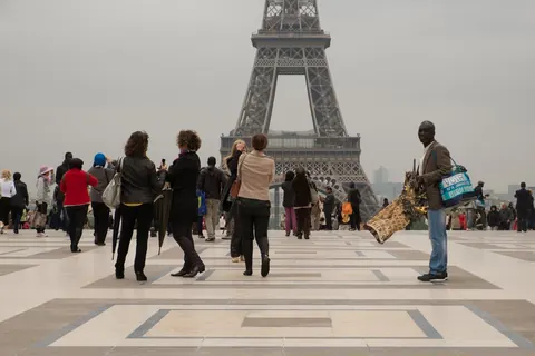 Gateselgere og turister på Trocadéro med Eiffeltårnet bak