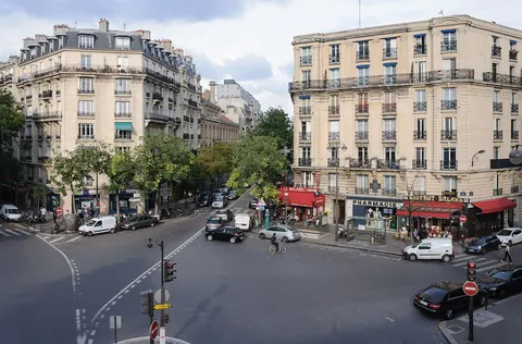 Gatekryss med bygårder og kafeer i Paris