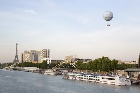 Eiffeltårnet sett fra Seinen med en elvebåt og en ballong